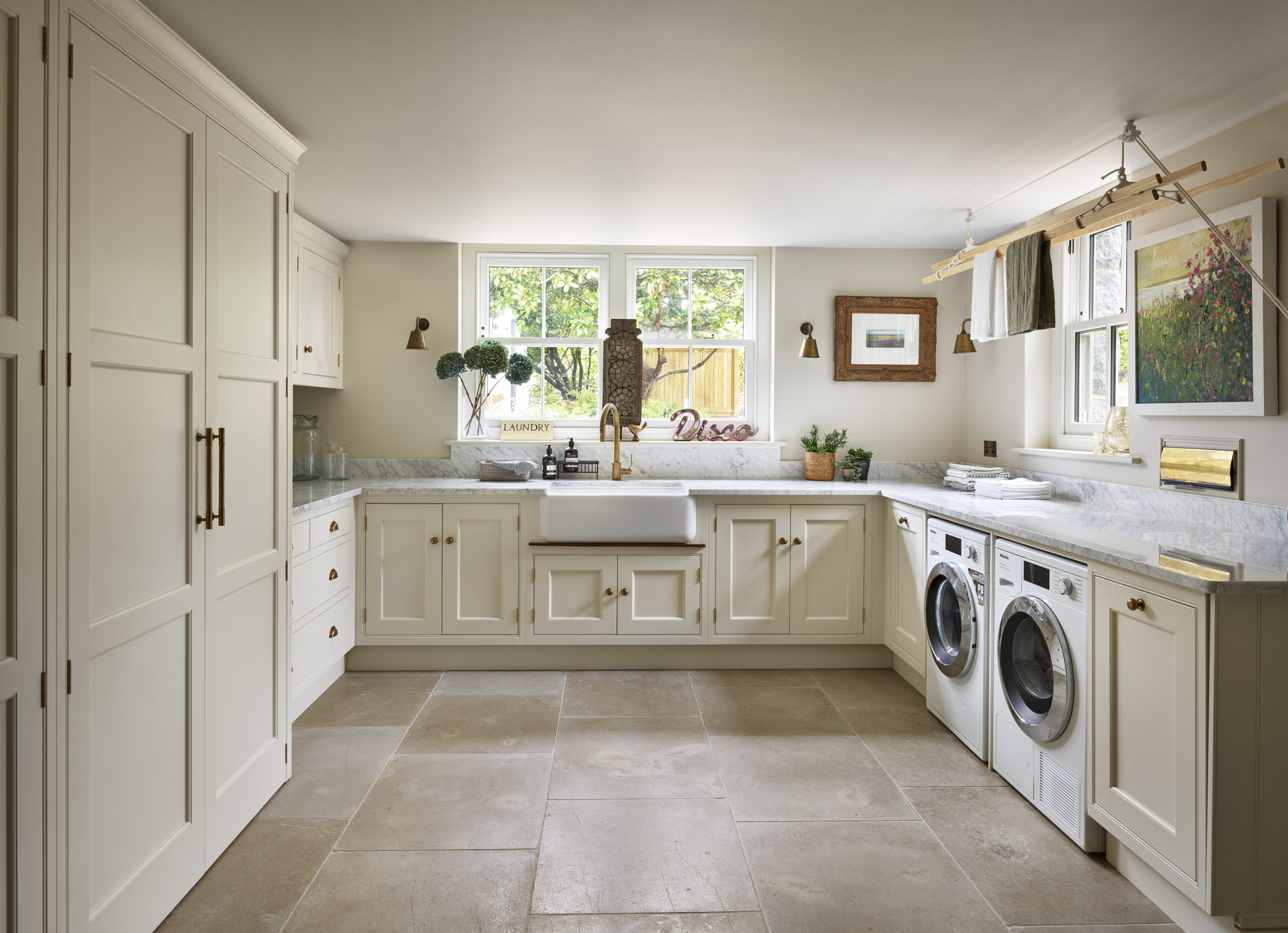 Utility space with ceiling mounted drying rack and stone flooring